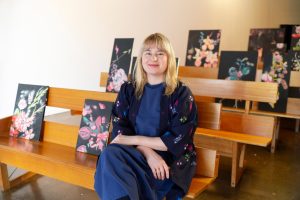 Josephine Mead in front of 24 paintings of my bridal bouquet